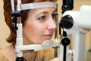 Woman undergoing eye exam with slit lamp machine during routine check-up at an optometry clinic